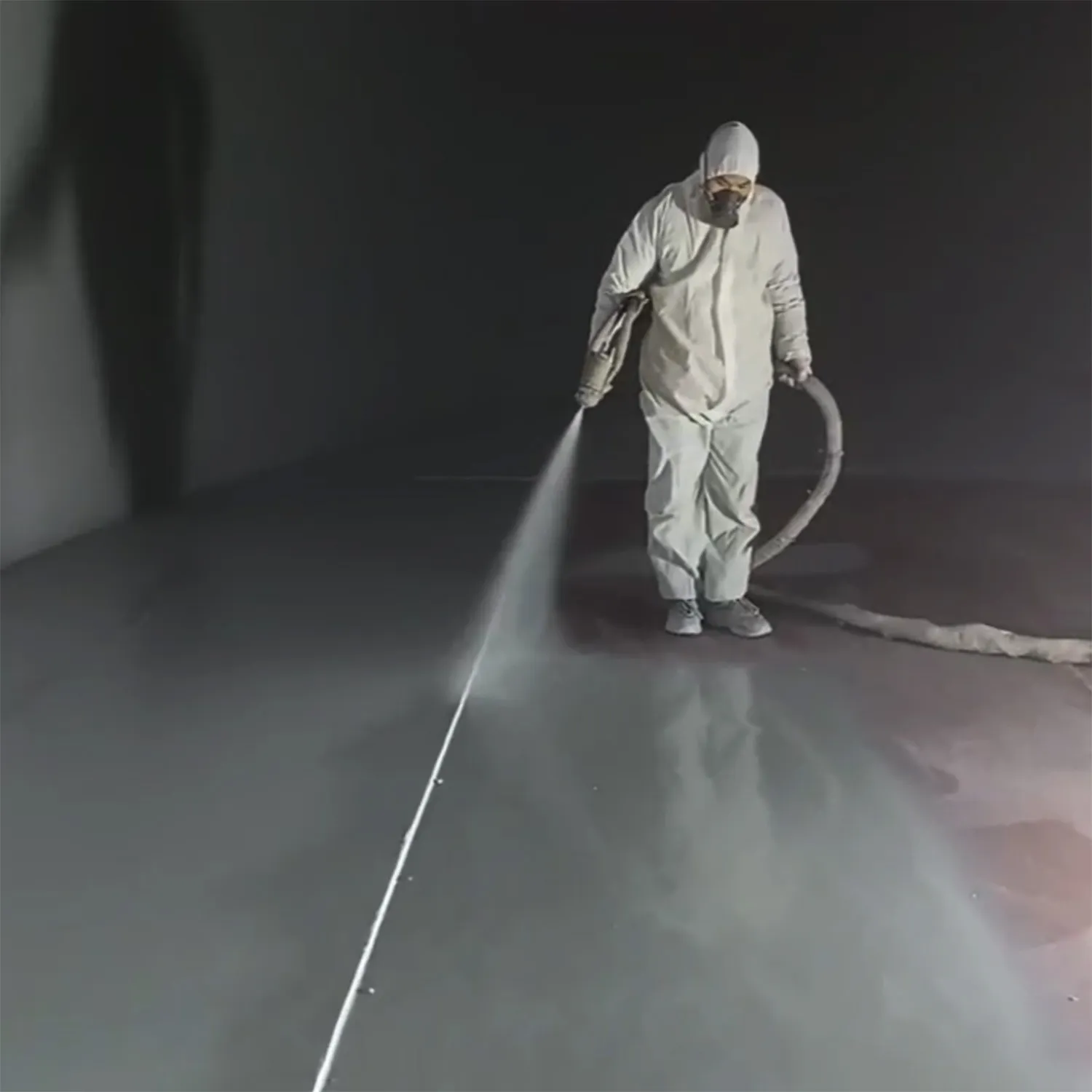 Spray polyurea floor coating application showing professional installer applying elastomeric coating system